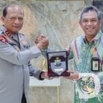 Kapolda Jatim Irjen Pol Nanang Avianto, memberikan cindera mata kepada Kakanwil DJP Jatim I Max Darmawan